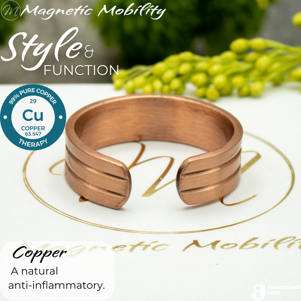 
                  
                    Load image into Gallery viewer, Back view of the Heath copper ring from Magnetic Mobility. Shown on a white gift box with green plants in the background. The writing says &amp;quot;Style and Function&amp;quot; and shows a Guaranteed irish logo. The back is open to allow for swelling of arthritic fingers. 
                  
                