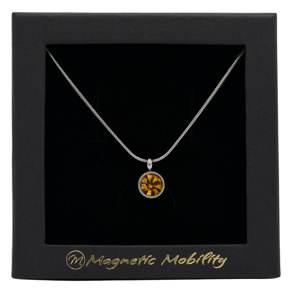 
                  
                    Load image into Gallery viewer, November Magnetic Mobility Birthstone Necklace featuring a Citrine Swarovski crystal pendant with a magnetic back. Ideal for relieving neck pain, displayed in a black box with Magnetic Mobility logo
                  
                