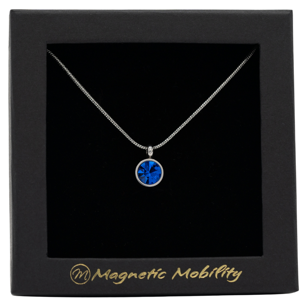 
                  
                    Load image into Gallery viewer, September Magnetic Mobility Birthstone Necklace with a blue Swarovski crystal pendant. Designed to help with neck pain relief, elegantly presented in black branded packaging.
                  
                